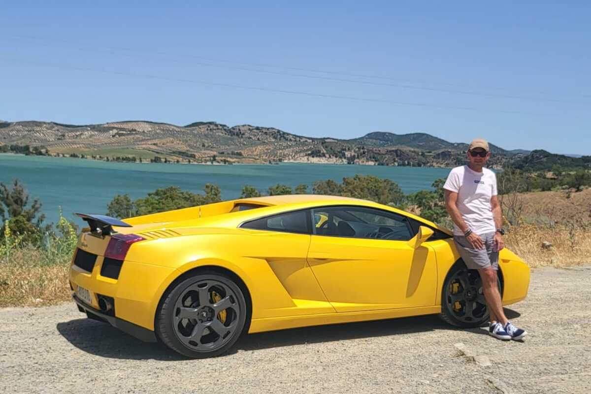 Justin Aldridge with his yellow Lamborghini Gallardo beside a lake